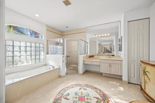 a spacious bathroom with a tub sink and mirror