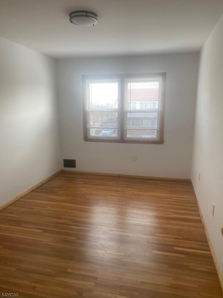 423 Clarkson Avenue, Unit 2 Elizabeth, NJ 07202 - Photo 11 of 16 an empty room with wooden floor and windows