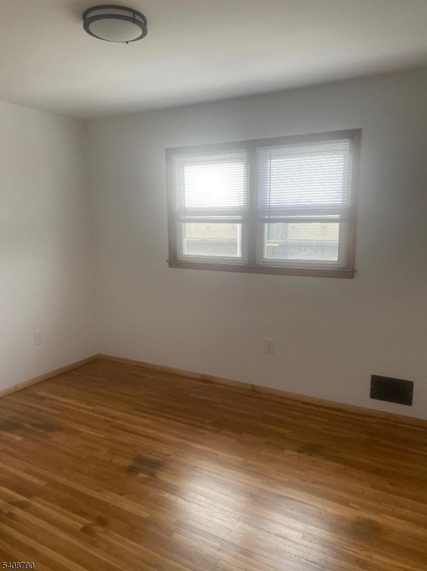 423 Clarkson Avenue, Unit 2 Elizabeth, NJ 07202 - Photo 13 of 16 a view of an empty room with wooden floor and a window