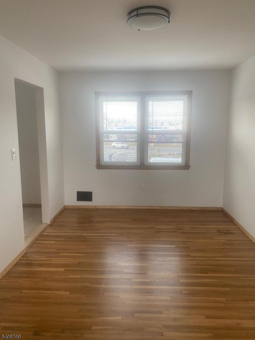 423 Clarkson Avenue, Unit 2 Elizabeth, NJ 07202 - Photo 2 of 16 a view of an empty room with wooden floor and a window