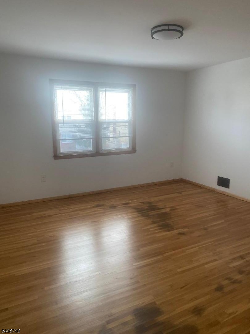423 Clarkson Avenue, Unit 2 Elizabeth, NJ 07202 - Photo 4 of 16 an empty room with wooden floor and windows