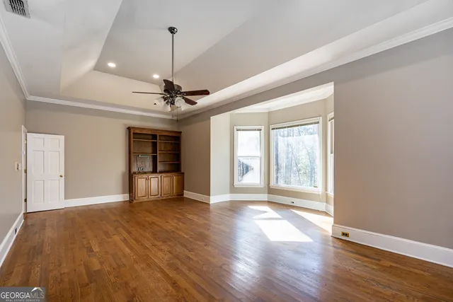 a spacious bathroom with a granite countertop double vanity sink a mirror and a bathtub
