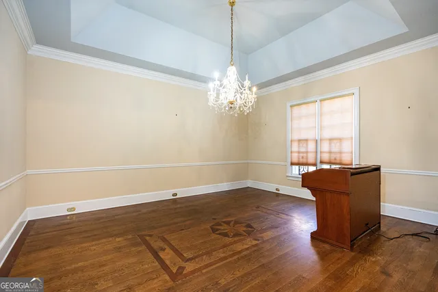 a view of an empty room with wooden floor and a fireplace