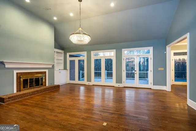 an empty room with wooden floor and fireplace