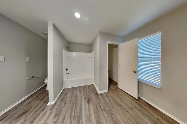 a view of a hallway with wooden floor and closet