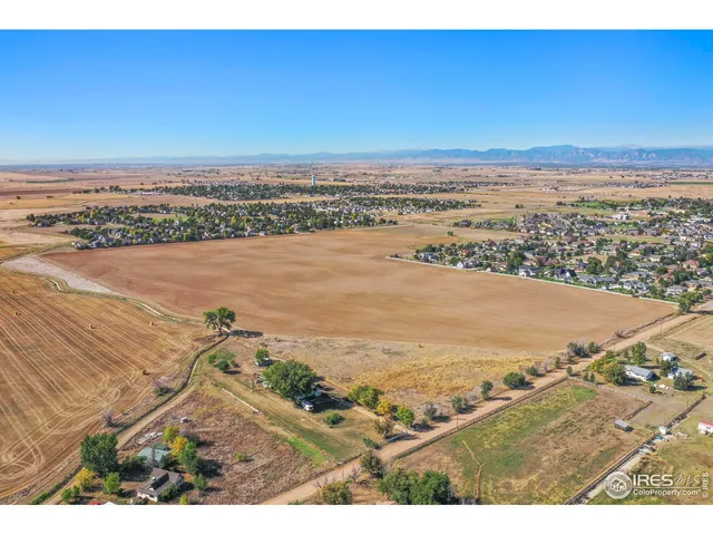 an aerial view of ocean and residential houses with outdoor space
