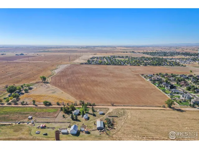 an aerial view of ocean and residential houses with outdoor space