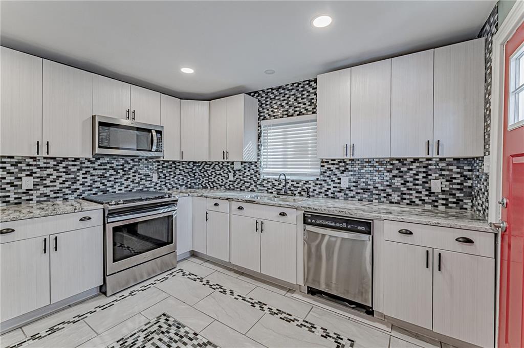 414 Hochberg Road Pittsburgh, PA 15235 - Photo 11 of 23 a kitchen with granite countertop white cabinets and black appliances