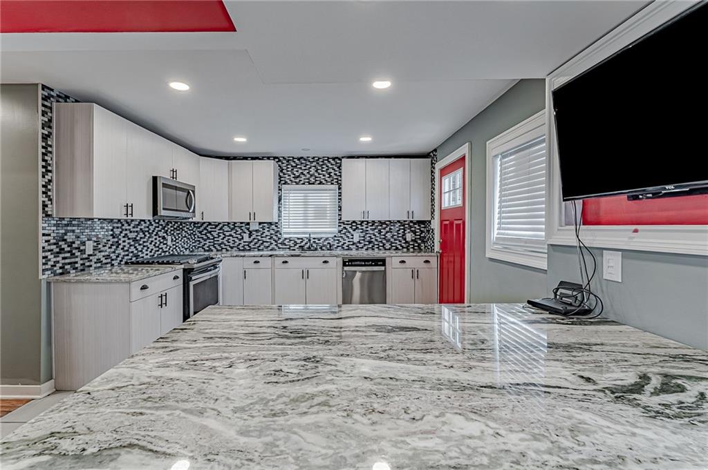414 Hochberg Road Pittsburgh, PA 15235 - Photo 13 of 23 a kitchen with stainless steel appliances kitchen island granite countertop a sink and a stove