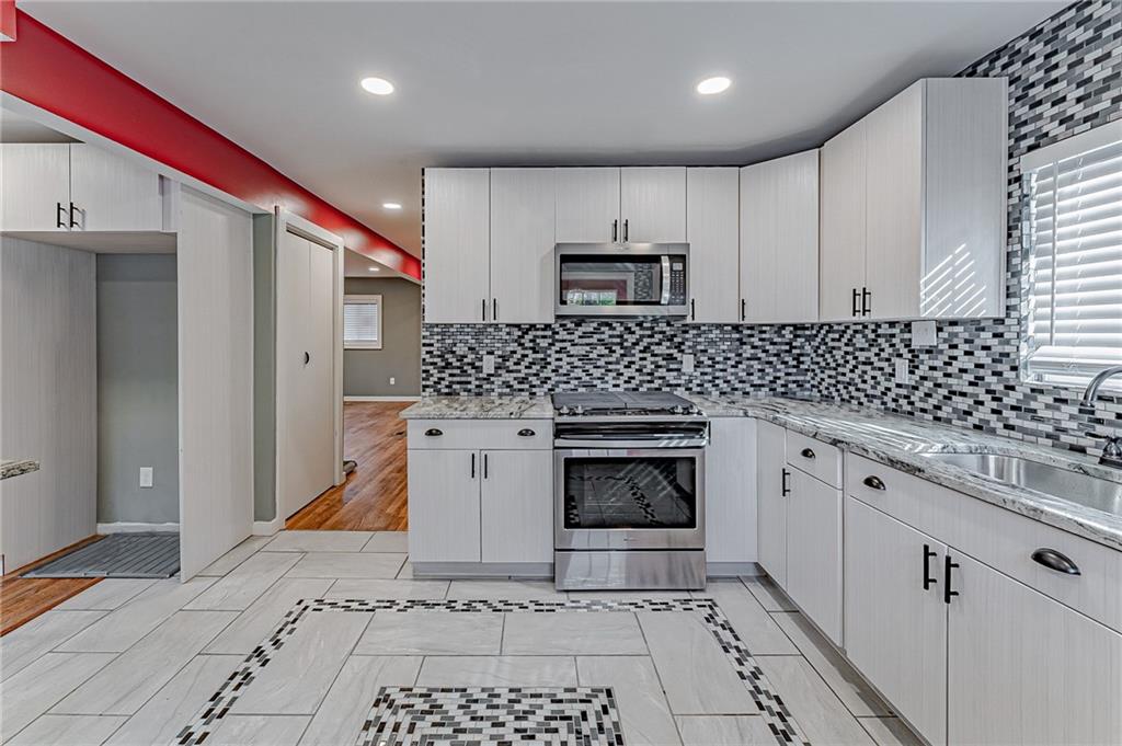 414 Hochberg Road Pittsburgh, PA 15235 - Photo 14 of 23 a kitchen with stainless steel appliances kitchen island granite countertop a sink stove and cabinets