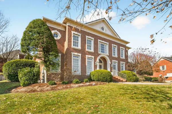 a view of a brick house with plants and large windows