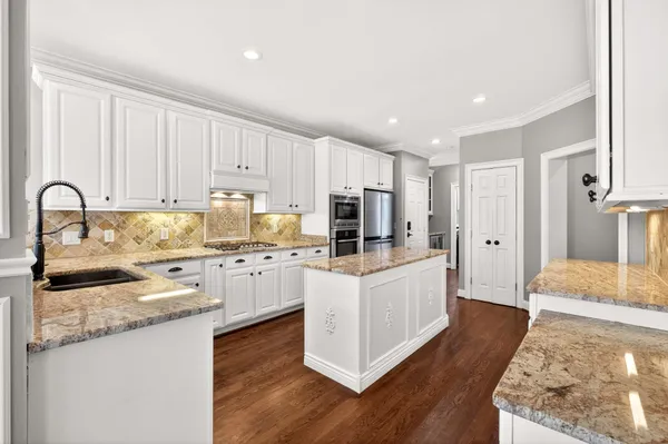 a kitchen with granite countertop white cabinets and white appliances