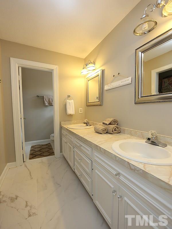 2501 Bredon Court Raleigh, NC 27613 - Photo 18 of 25 a en suite bathroom with a double vanity sink and a mirror