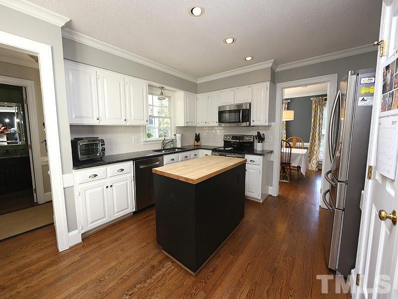 2501 Bredon Court Raleigh, NC 27613 - Photo 6 of 25 a kitchen with a stove sink cabinets and refrigerator