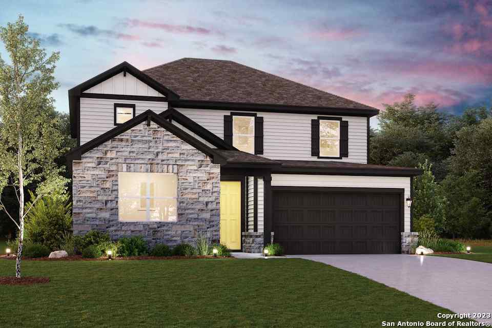 a front view of a house with a garden and yard