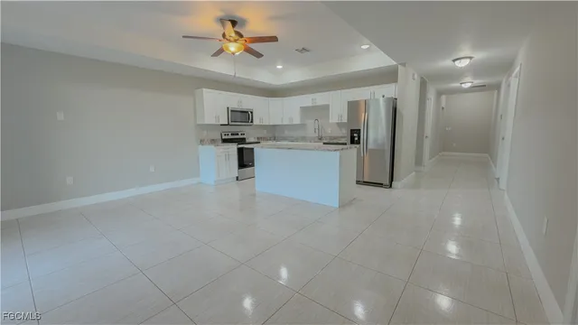 a large kitchen with kitchen island a sink stainless steel appliances and cabinets