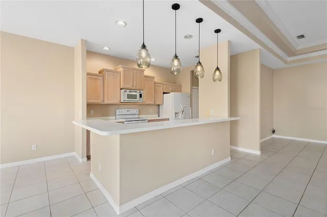 a large white kitchen with a sink a refrigerator and a stove