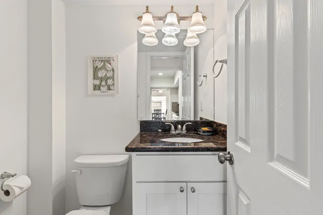 a bathroom with a sink vanity mirror and toilet