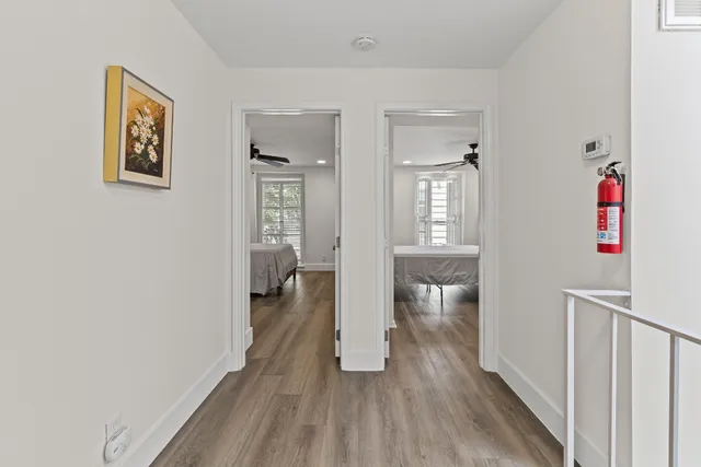 a hallway with wooden floor closet and bathroom
