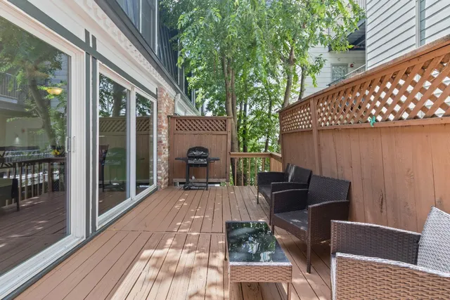 a view of a patio with table and chairs and floor to ceiling window with wooden floor