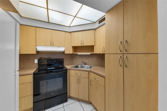 a kitchen with stainless steel appliances granite countertop a sink and a refrigerator