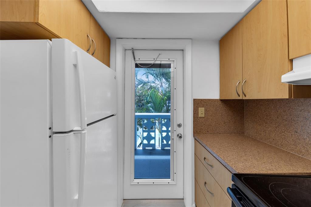 2151 Northeast 42nd Court, Unit 230 Lighthouse Point, FL 33064 - Photo 23 of 40 a kitchen with a refrigerator and a stove
