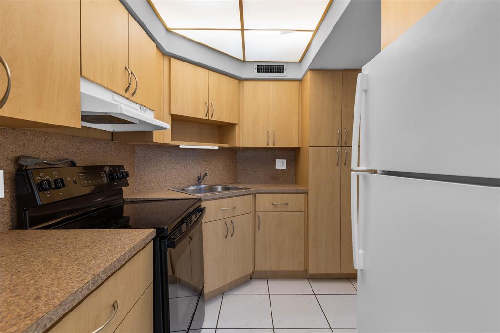 2151 Northeast 42nd Court, Unit 230 Lighthouse Point, FL 33064 - Photo 25 of 40 a kitchen with stainless steel appliances granite countertop a sink and a stove