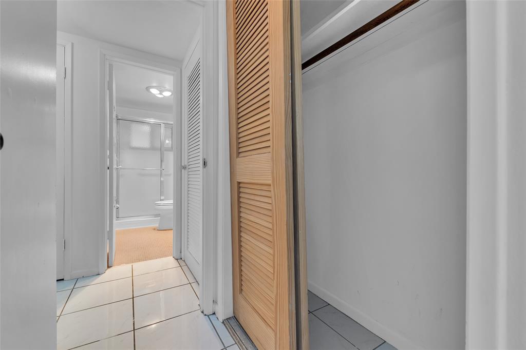 2151 Northeast 42nd Court, Unit 230 Lighthouse Point, FL 33064 - Photo 32 of 40 a bathroom with a glass shower door