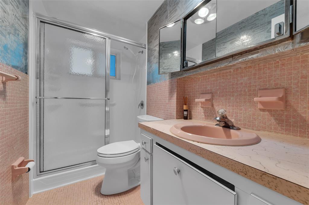 2151 Northeast 42nd Court, Unit 230 Lighthouse Point, FL 33064 - Photo 34 of 40 a bathroom with a sink a toilet and a mirror