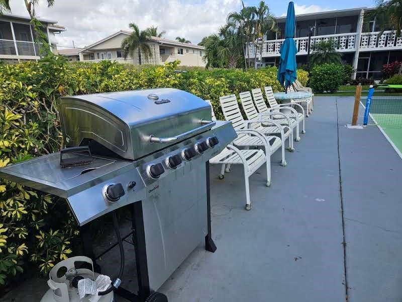 2151 Northeast 42nd Court, Unit 230 Lighthouse Point, FL 33064 - Photo 10 of 40 a view of a chairs and table in backyard