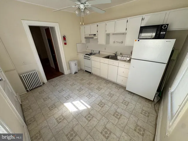 a kitchen with white cabinets and white appliances
