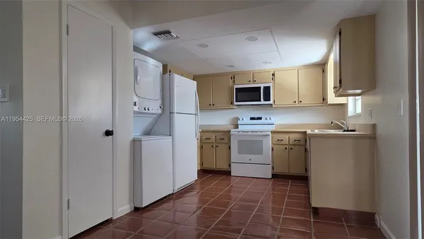 a kitchen with a sink a stove top oven and cabinets