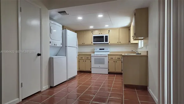 a kitchen with a sink a refrigerator and cabinets