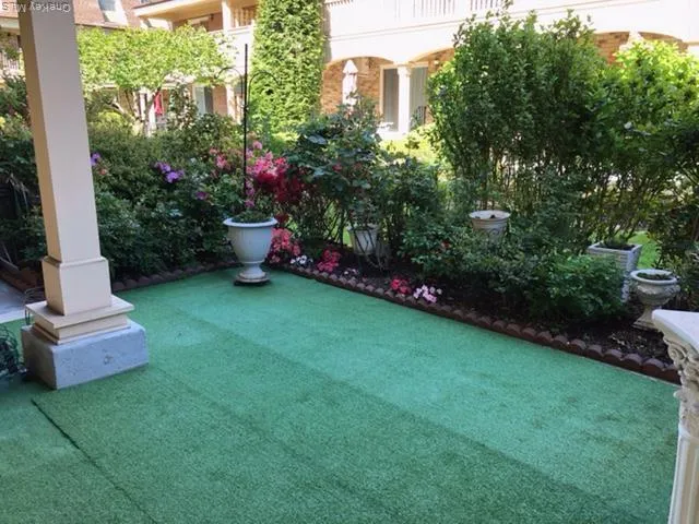 a front view of a house with a garden and trees