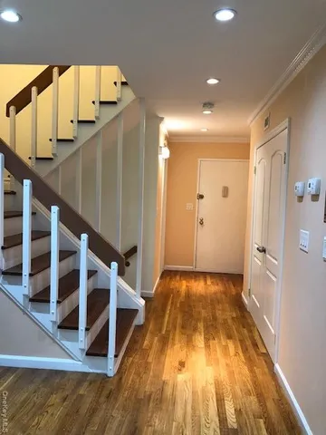a view of a hallway with wooden floor and staircase