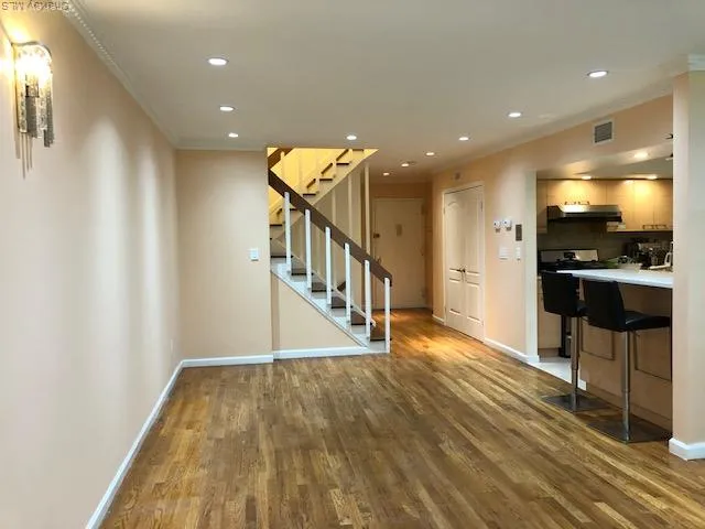 a view of a hallway with wooden floor and livingroom