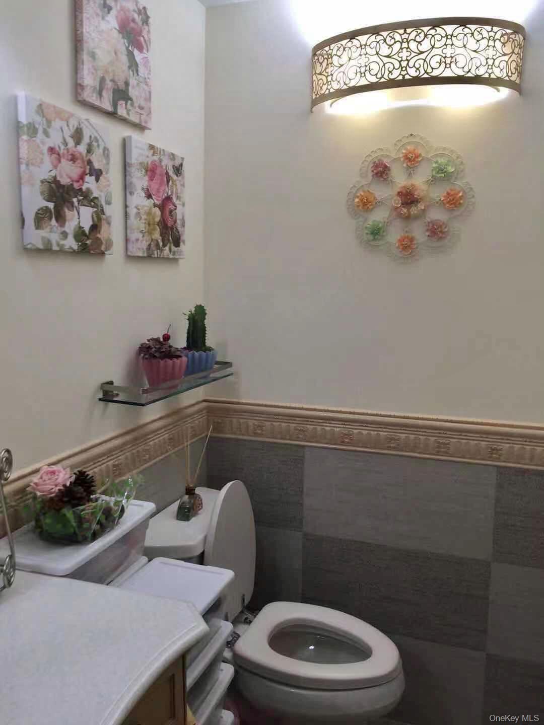 12-31 Robin Lane, Unit TRIPLEX Queens, NY 11360 - Photo 10 of 17 a bathroom with a toilet a sink and mirror