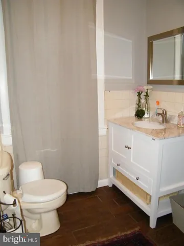 a bathroom with a toilet sink and a mirror