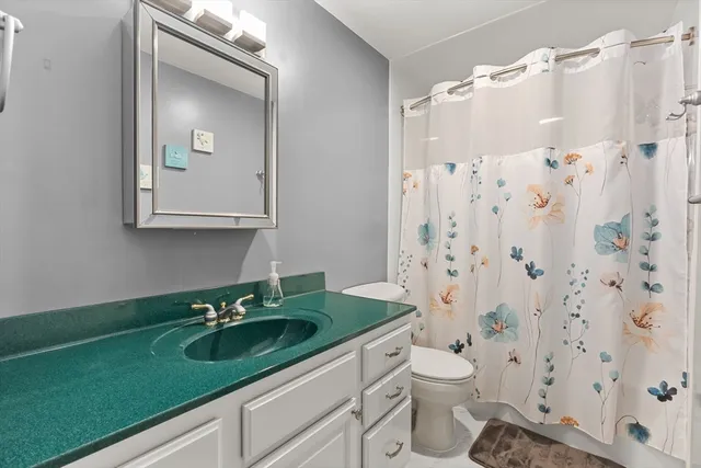 a bathroom with a granite countertop sink toilet and shower