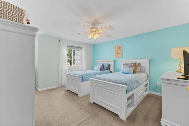 a spacious bedroom with two beds and a chandelier