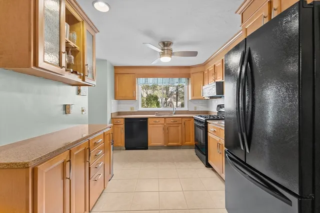 a kitchen with stainless steel appliances granite countertop a refrigerator a sink dishwasher a stove with white cabinets and wooden floor