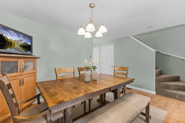 a view of a dining room with furniture a chandelier and wooden floor