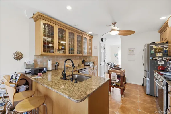 a kitchen with stainless steel appliances granite countertop a sink a stove and a refrigerator