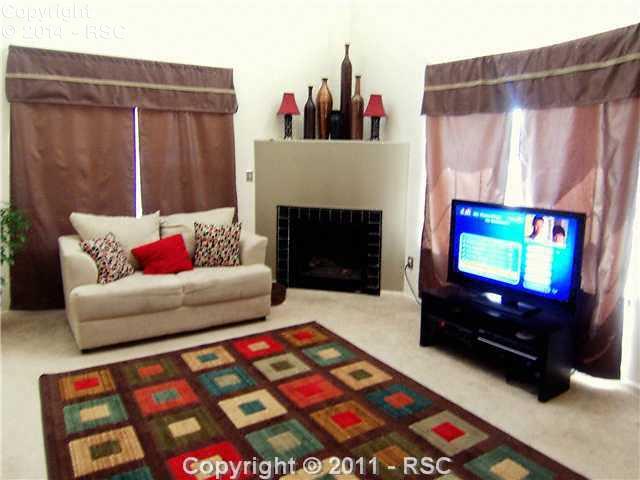 1605 Monterey Road, Unit A Colorado Springs, CO 80910 - Photo 2 of 16 Large Living Room with Gas Fireplace, Vaulted Ceiling & light, neutral colors