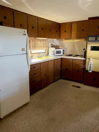 a kitchen with cabinets a refrigerator and a sink