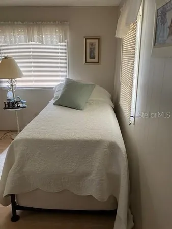 a bed sitting in a bedroom next to a window