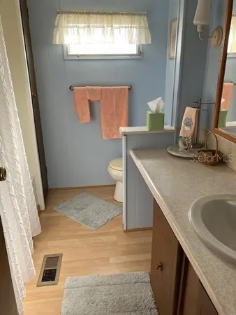 a bathroom with a granite countertop sink a toilet and a mirror