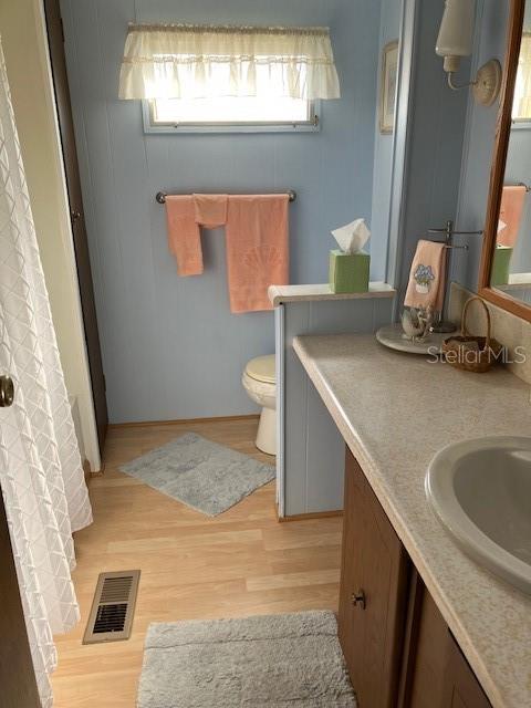 3405 Lanark Drive Holiday, FL 34690 - Photo 22 of 32 a bathroom with a granite countertop sink a toilet and a mirror
