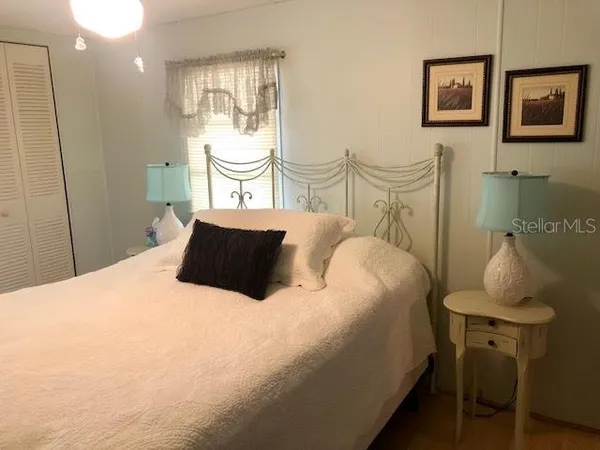 a bedroom with a bed and painting on the wall