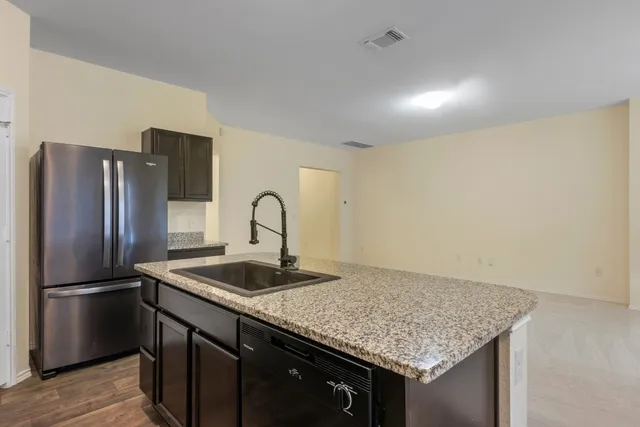 a kitchen with stainless steel appliances granite countertop a refrigerator and a stove